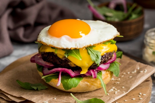 Cheeseburger with a fried egg on a cutting board